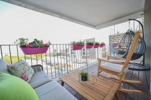 a balcony with a couch and a swing and some plants at YalaRent Migdalor Boutique Hotel Apartments with Sea Views Tiberias in Tiberias