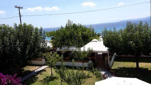 a house with a white roof and some trees at Ammos Studios and Apartments in Mikro