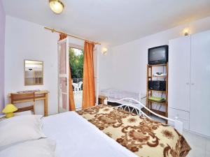 sypialnia z łóżkiem, biurkiem i telewizorem w obiekcie Apartments Miro 636 w Rovinj
