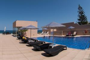 a hotel room with a pool, chairs, and a pool table at Archipelagos Hotel in Rethymno