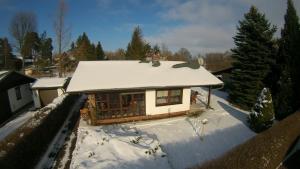 uma pequena casa com um telhado coberto de neve em Ferienhaus am Schwielochsee em Schwielochsee