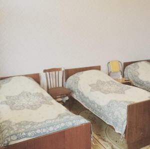 ギャンジャにあるHuseyn Housesのベッド2台と椅子2脚が備わる客室です。