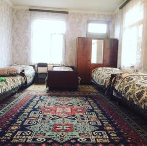 a room with two beds and a rug at Huseyn Houses in Ganja