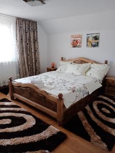 1 dormitorio con 1 cama con marco de madera en Casa Stefi si Alexia, en Polovragi