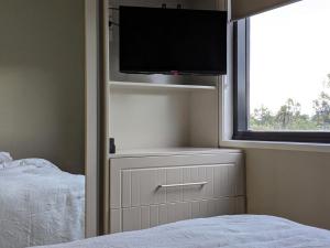 a bedroom with a bed and a flat screen tv at The Botanical 301 in Albury
