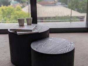 a table and stool with two cups on top of it at The Botanical 301 in Albury