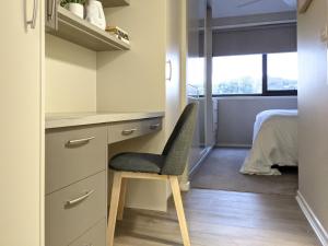 a desk and a chair in a room with a bed at The Botanical 301 in Albury +5 photos