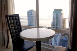 una mesa y una silla en una habitación con ventana en Regency Grand Suites, en Manila