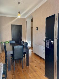a dining room with a table and chairs and a refrigerator at Elegance in Sighnaghi