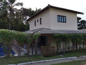 a white house with trees in front of it at Recanto do Angelo in Salvador