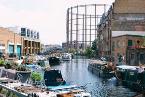 a group of boats in a river with a ferris wheel at Beautiful apartment right off of Broadway Market in London