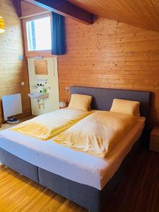ein Schlafzimmer mit einem großen Bett in einem Holzzimmer in der Unterkunft Casi in Brienz