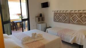 um quarto de hotel com duas camas com toalhas em S'Apposentu ( La Camera) em Villasimius