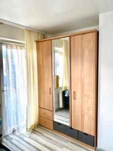 un gran armario de madera en una habitación con ventana en Klein aber dein..., en Pforzheim