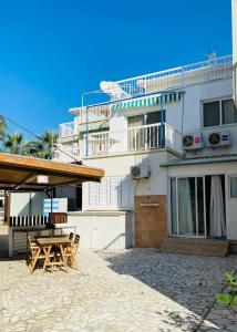 ein Gebäude mit einem Picknicktisch davor in der Unterkunft Artemis Beach Apartment in Pyla