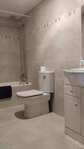 uma casa de banho com um WC, um lavatório e uma banheira em Apartamento VUT manypi VU-HUESCA-21-024 em La Puebla de Castro