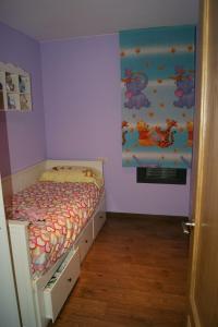 - une petite chambre avec un lit dans une chambre violette dans l'établissement Apartamento VUT manypi VU-HUESCA-21-024, à La Puebla de Castro