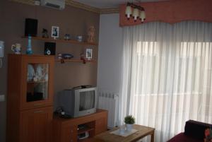 uma sala de estar com uma televisão e uma janela em Apartamento VUT manypi VU-HUESCA-21-024 em La Puebla de Castro