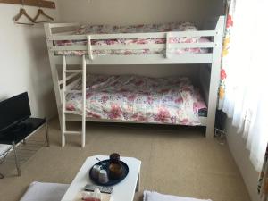 a room with two bunk beds and a table at STAY Akeboshi Kan in Hakodate