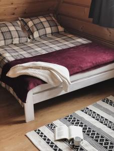 a bed with a blanket and books on the floor at Pokoje u Małgorzatki in Murzasichle