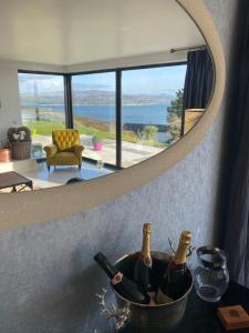 a bowl of wine bottles on a counter in front of a mirror at Sea Vista Boutique Accommodation in Fahan