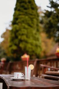 a wooden table with a cup and a drink on it at Restoran Lovac in Novi Kneževac