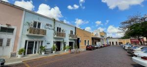 a street in a town with cars parked at Hotel La Piazzetta in M&eacute;rida
