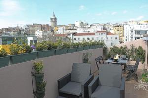 een balkon met een tafel en stoelen en uitzicht op de stad bij Karaköy VAV Suites in Istanbul