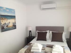 a bedroom with a bed and a painting on the wall at Sikelela Guest House in Cape Town