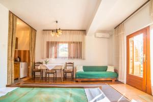a living room with a table and a green couch at Apartments Antić 4255 in Selce