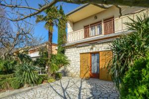 a large house with a balcony and a driveway at Apartments Antić 4255 in Selce