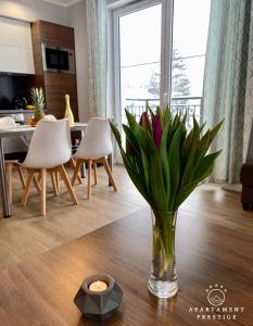 a vase of flowers on a table in a living room at Apartament Prestige Szklarska Poręba in Szklarska Poręba