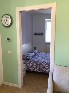 um quarto com uma cama e um relógio na parede em Il Bosco - vicino al lago, vicino alle montagne em Ballabio