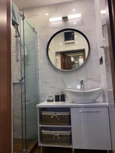 uma casa de banho com um lavatório e um espelho em Rose Lux em Belgrado