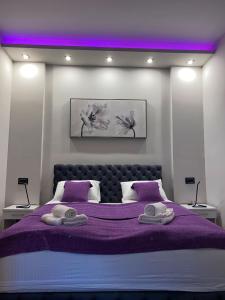 a bedroom with a purple bed with two towels on it at Rose Lux in Belgrade