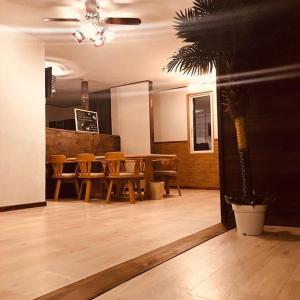 a dining room with a table and chairs and a palm tree at コテージトガワ＜Cottage TOGAWA＞ in Fujikawaguchiko