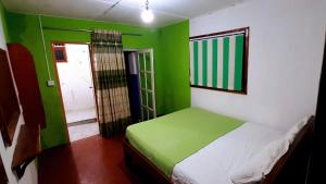 a bedroom with green and white walls and a bed at Fallside Rest in Norton Bridge
