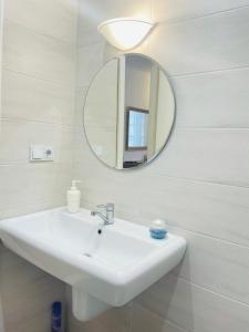 a bathroom with a white sink and a mirror at Studio flat in Chişinău