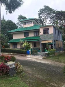 une grande maison avec un toit vert dans l'établissement Villa Green Fresh - Bumi Ciherang - Cipanas, à Cianjur