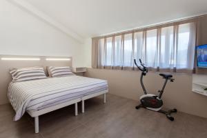 a bedroom with a bed and a exercise bike at Bed & Bike in Aulla