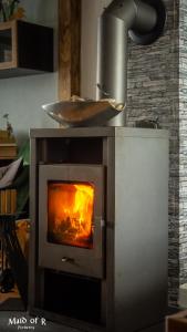 a stove with a fire inside of it at Studio - grosses Wohn-Schlafzimmer - Dachterrasse - Kamin - Küche - Hohes Venn - Monschau - Eifel - Hunde willkommen beim Hof Vierzehnender in Monschau