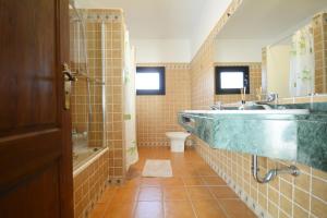 a bathroom with a sink and a tub and a toilet at Beautiful spacious villa with private heated pool in Lajares in Lajares +31 photos