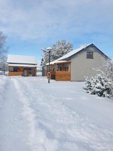 a house is covered in snow with a driveway at Zakątek w Zaciszu in Ustka