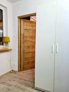 een houten deur in een kamer met een lamp bij Apartament Wałbrzych / Piaskowa Góra in Wałbrzych