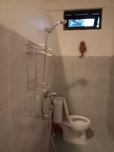 a bathroom with a toilet with a shower and a window at Villa Green Fresh - Bumi Ciherang - Cipanas in Tjiandjur