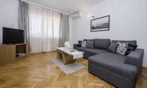 a living room with a couch and a tv at Apartments Bolero in Rab