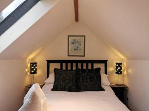 a bedroom with a bed with white sheets and two lamps at The Compasses Inn in Fordingbridge