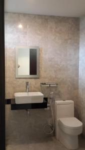 a bathroom with a sink and a toilet and a mirror at White Rock Lodge in Nusa Dua
