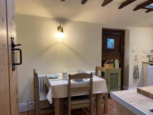 a dining room with a table with chairs and a light at Rock View Cottage, 2 bedrooms near Alton Towers in Alton