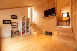 a living room with wooden floors and a tv and stairs at Loft Coco in Luchon